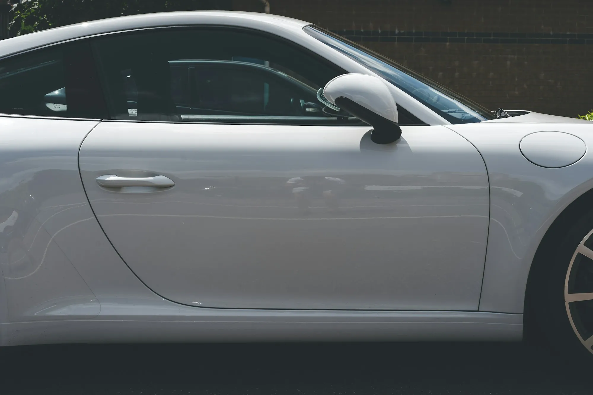 Side view of a silver sports car's door and rear fender