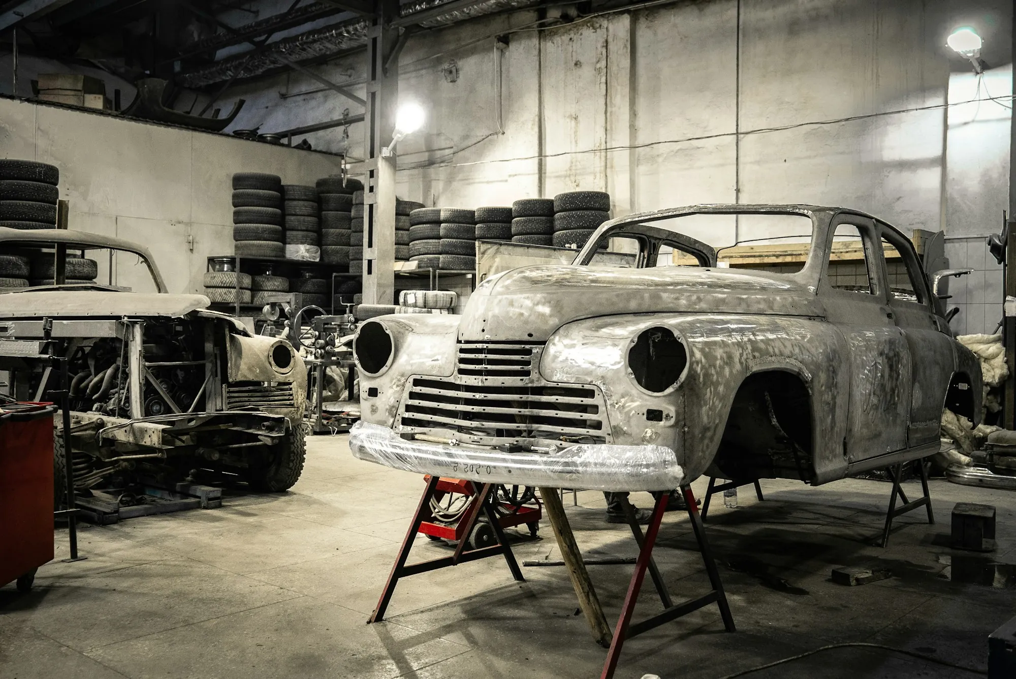 Classic car body stripped to bare metal inside a restoration shop